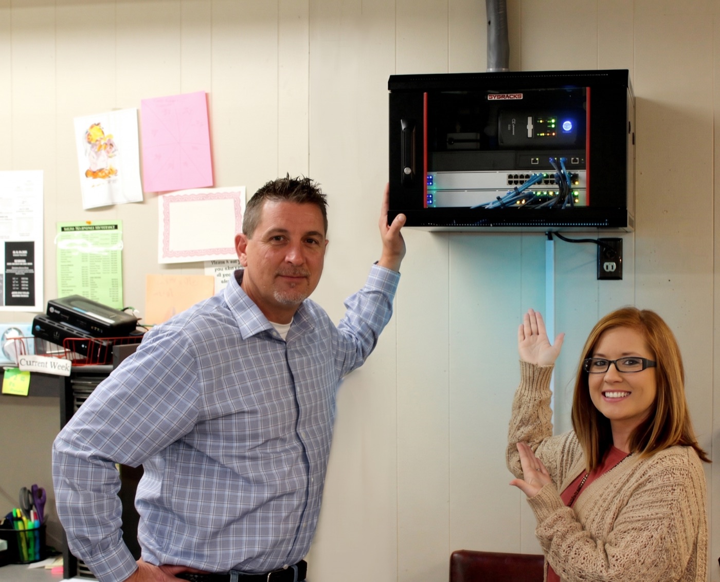 An Alabama Lightwave technician and a happy customer next to her newly installed network cabinet.